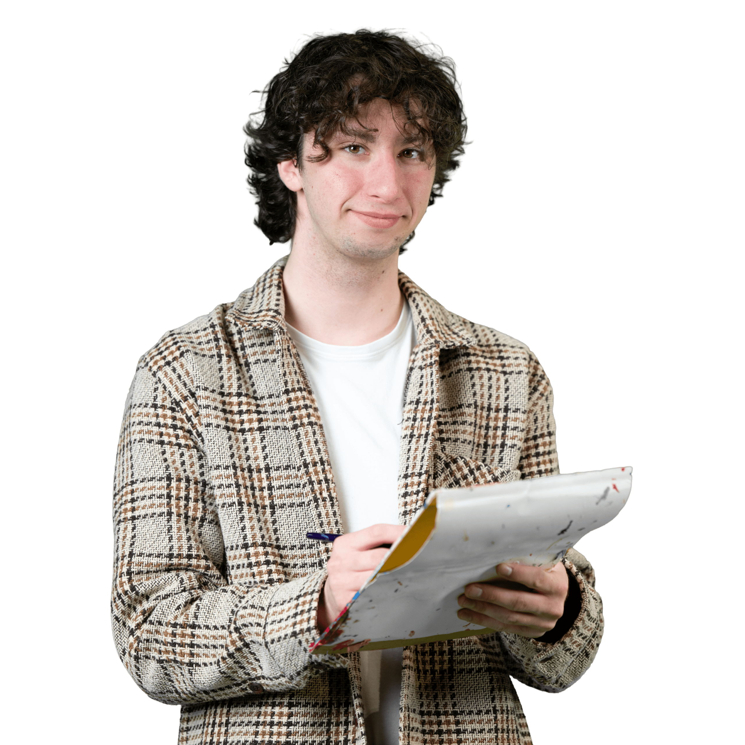 Une personne aux cheveux bouclés, vêtue d'une veste à carreaux et d'une chemise blanche, sourit et tient un bloc-notes avec des feuilles, sur lequel elle écrit avec un stylo. L'arrière-plan est blanc.