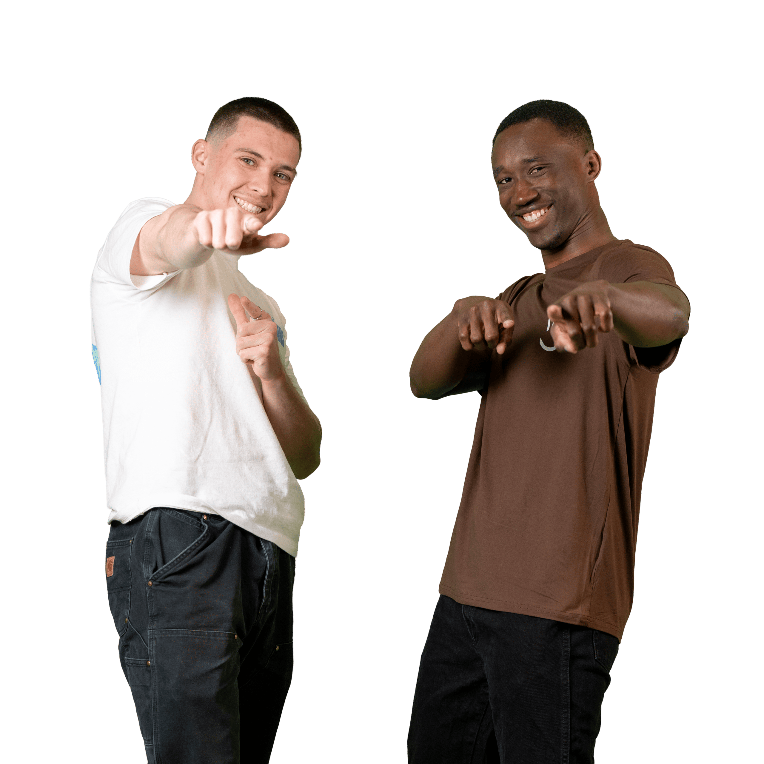 Deux hommes se tiennent côte à côte, souriants, et montrent du doigt l'appareil photo. L'un porte un t-shirt blanc et l'autre un t-shirt marron. L'arrière-plan est uni et blanc.