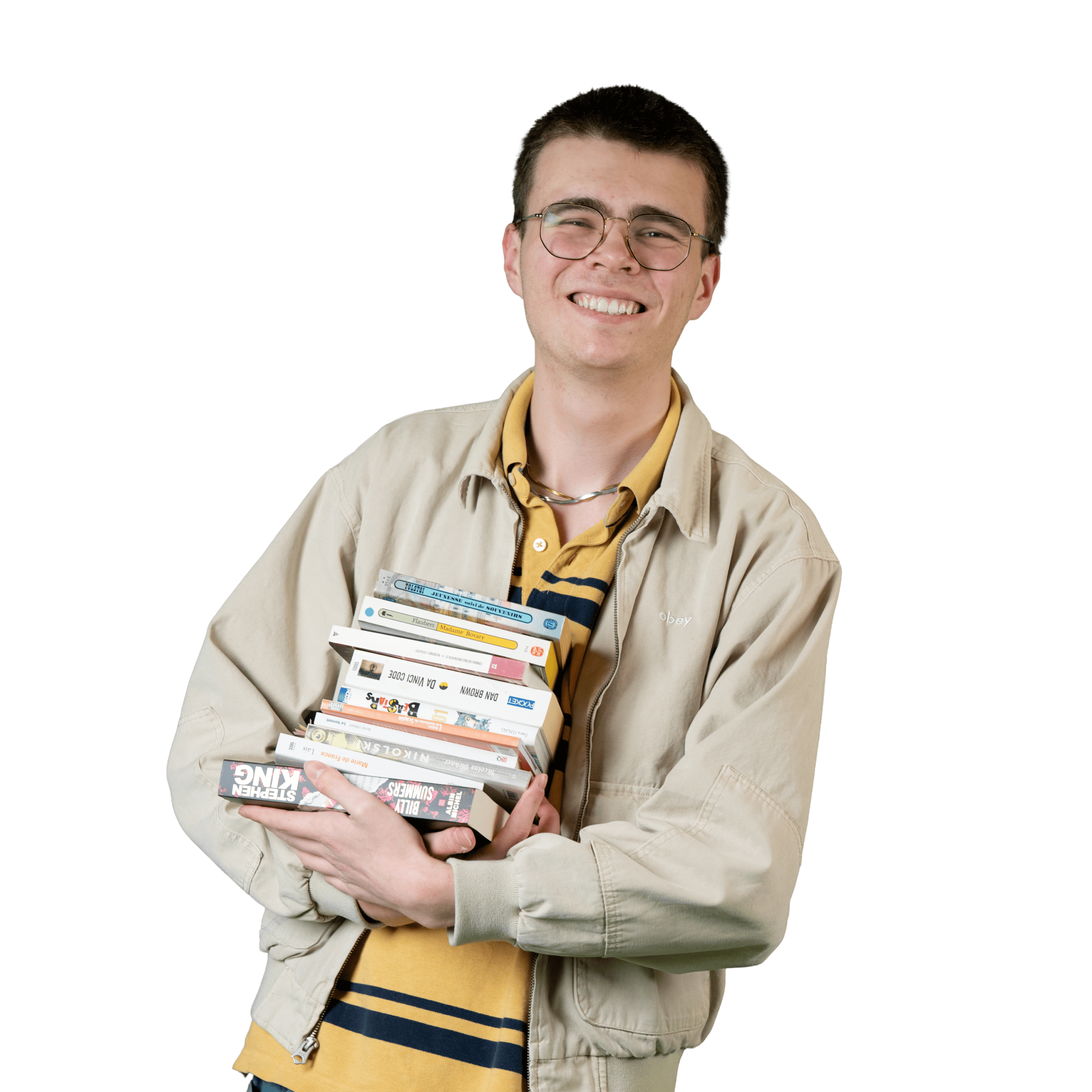 Une personne souriante, portant des lunettes et une veste beige, tient une pile de livres et de DVD devant un fond blanc.