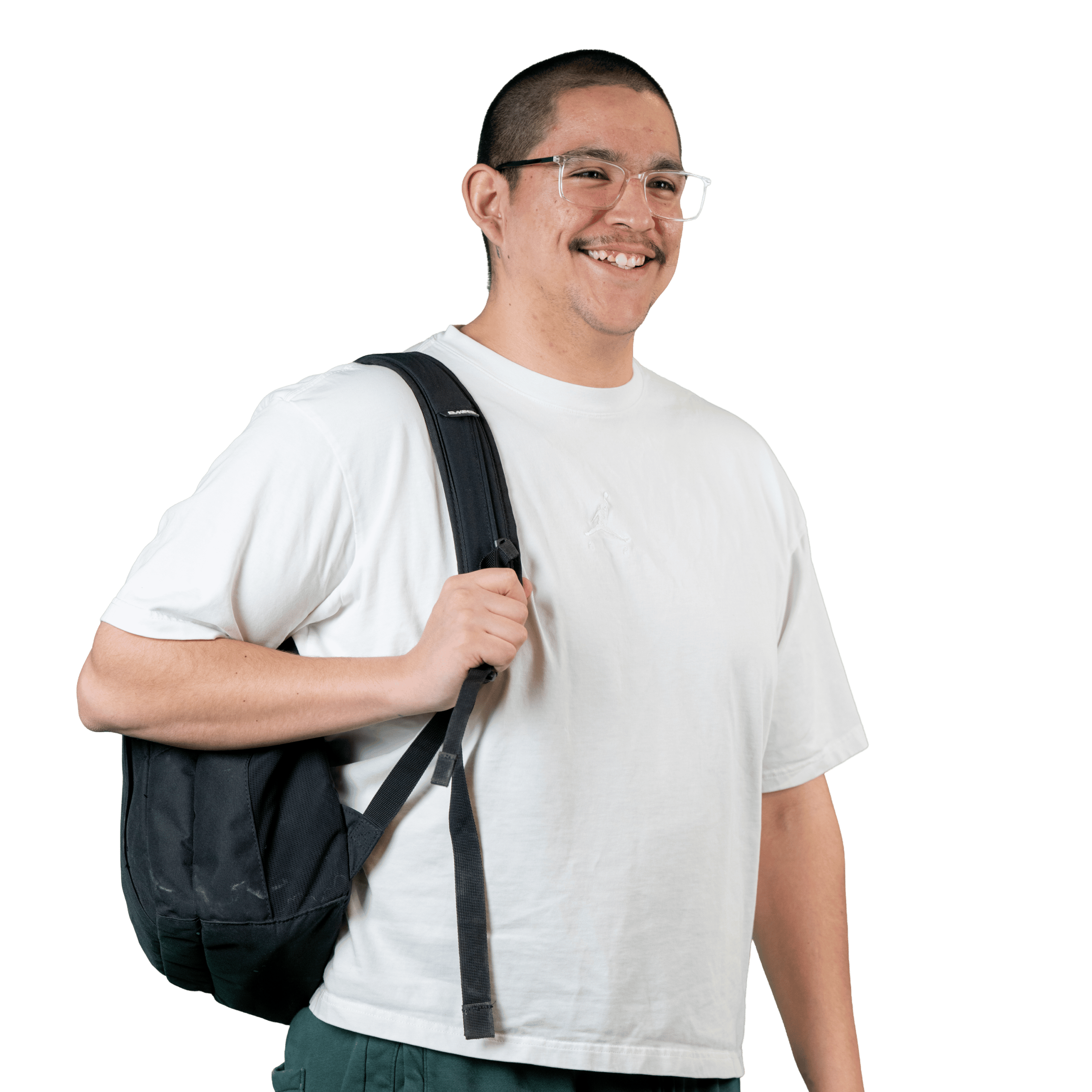 Un homme souriant, aux cheveux courts et portant des lunettes, est vêtu d'un t-shirt blanc et porte un sac à dos noir en bandoulière ; il se tient debout devant un fond blanc uni.