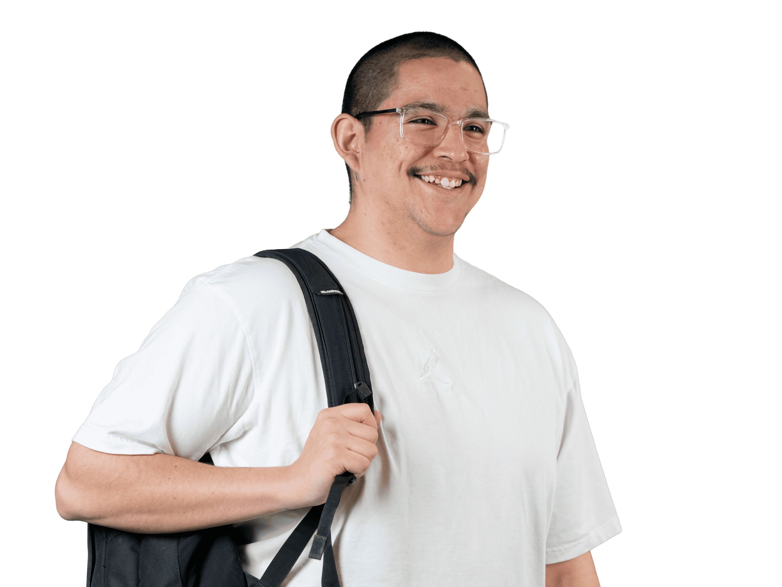 Un homme souriant, portant des lunettes et un t-shirt blanc, la sangle d'un sac à dos noir en bandoulière, se tient debout devant un fond blanc uni.